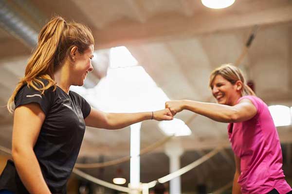 workout partners bump fists in celebration