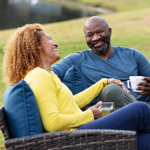 Smiling couple having coffee outside