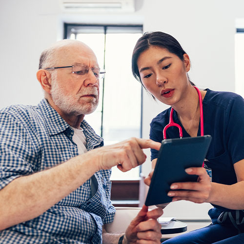 Person looking at tablet with doctor