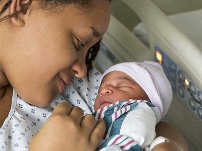 mother looks affectionately at her newborn child