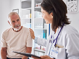 A doctor talks to a patient in an exam room