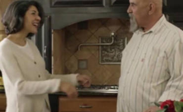 A husband and wife talking in their house