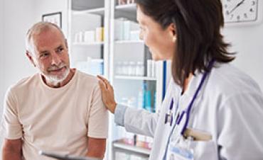 A doctor talks to a patient in an exam room